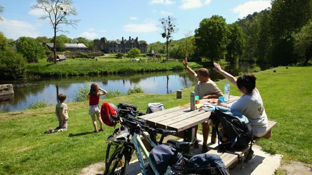 Pause pique-nique lors d'une balade à vélo en famille, devant l'Abbaye de Bon-Repos