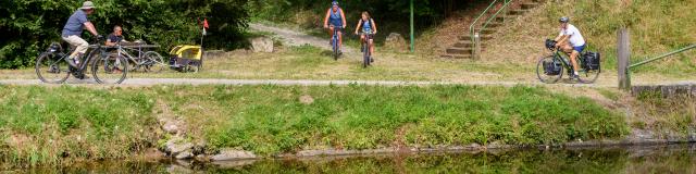 Cyclotouristes se croisant sur le chemin de halage le long du Canal de Nantes à Brest et à la rampe d'accès aux Voies Vertes et à la Vélodyssée, à Pont ar Brost à Carhaix