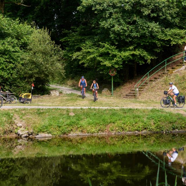 Cyclotouristes se croisant sur le chemin de halage le long du Canal de Nantes à Brest et à la rampe d'accès aux Voies Vertes et à la Vélodyssée, à Pont ar Brost à Carhaix